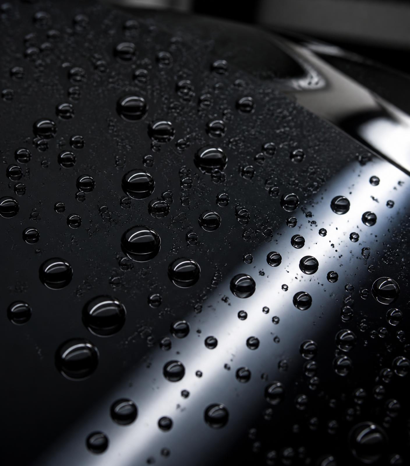 Water beading tightly on a slick, glossy black hood